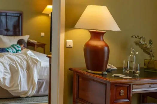 Nobler Schreibtisch mit Tischleuchte und Blick auf das Bett im Familienzimmer des Louisa's Place Hotel Kudamm Berlin