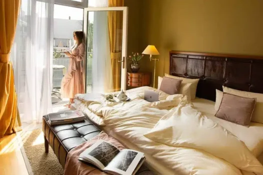 Frau steht am Fenster im Premium Apartment des Louisas Place Berlin