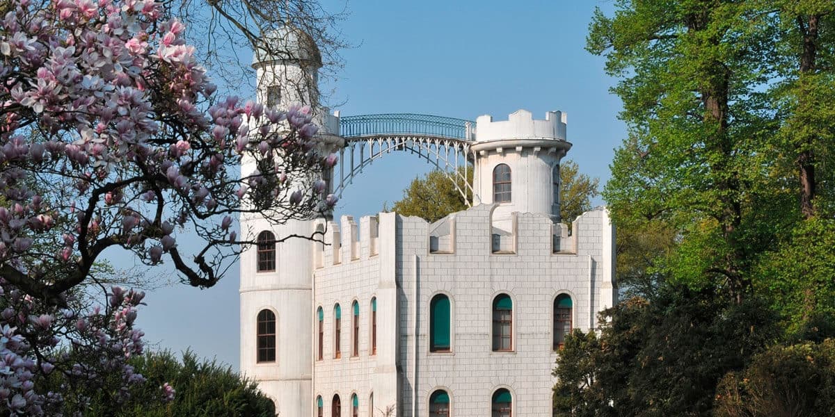 Weißes Schloss auf der Pfaueninsel mit Bäumen und Blüten, der ehemalige Sommersitz der Königin Luise