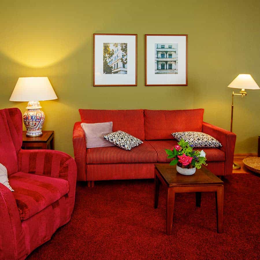 Komfortables Sofa und Beistelltisch mit Blumenstrauß im Deluxe Zimmer des Louisa's Place Hotels