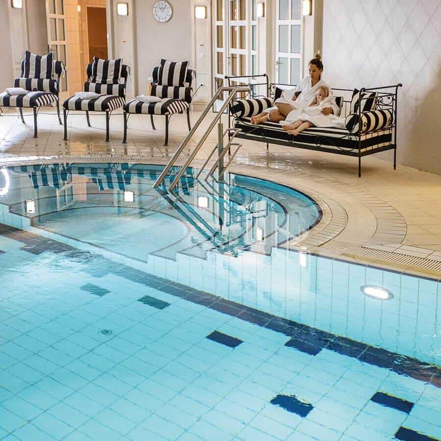 Frau mit Kind auf einer Bank im Schwimmbad des Louisa's Place am Kudamm Berlin