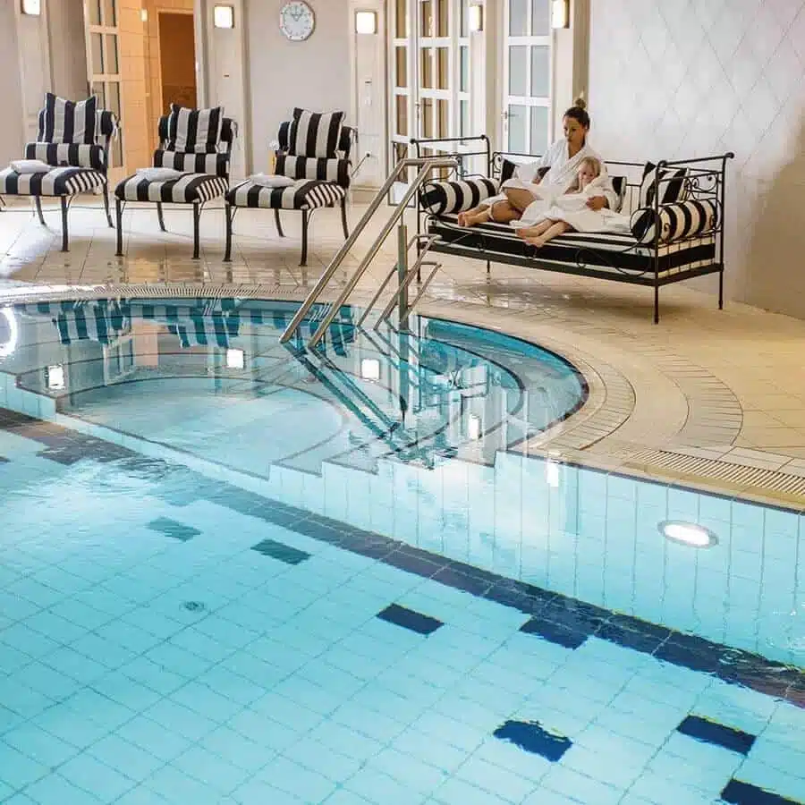 Frau mit Kind auf einer Bank im Schwimmbad des Louisa's Place am Kudamm Berlin