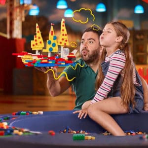 Vater und Tochter spielen mit einem Lego Piratenschiff.