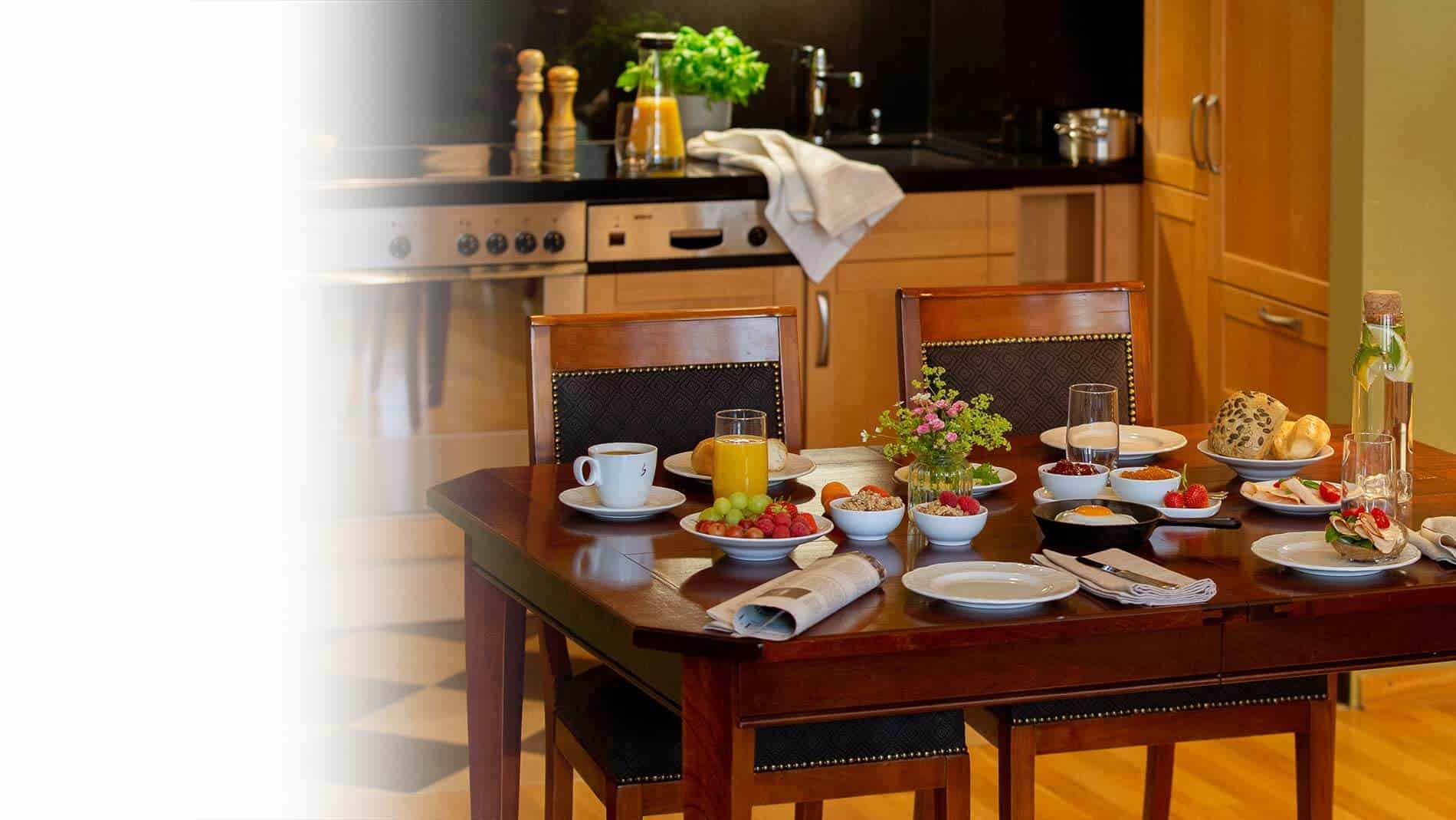 Reichlich gedeckter Frühstückstisch in vollausgestatteter Küche der Grand Suite im Louisa's Place Berlin