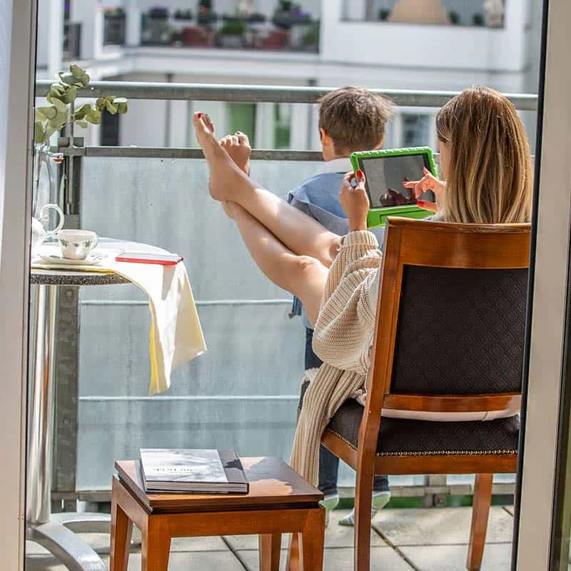 Frau und Kind schauen vom Balkon in den Innenhof des Louisas Place Berlin