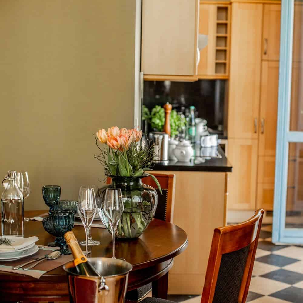 Großzügige Küche mit geschmackvoll gedecktem Tisch und gläserner Tulpenvase in Louisa's Suite