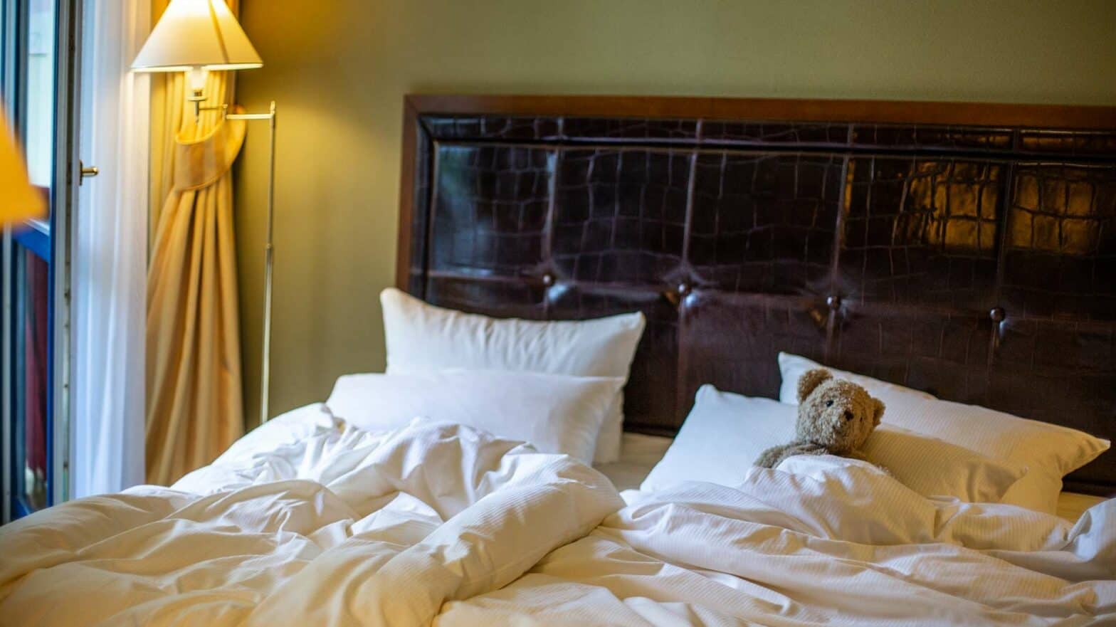 Teddybär eingekuschelt im Bett der Louisa Suite